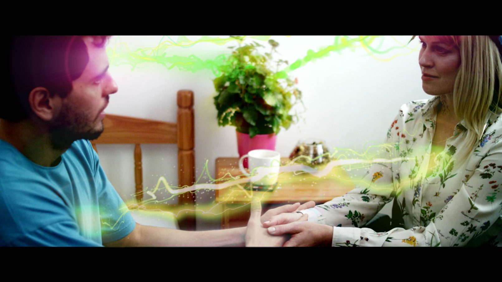 Photo showing VFX of simulated chakra energy lines passing between two people and organic matter